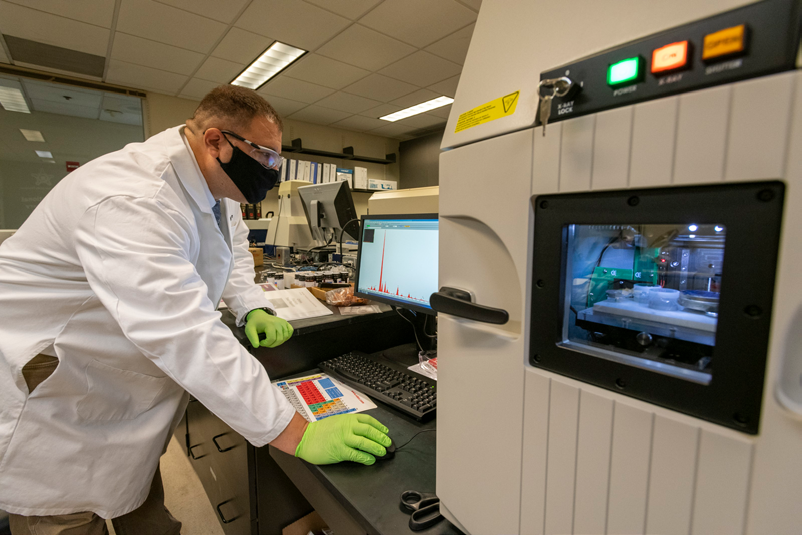 A senior Chemist evaluates the chemical elements of an ink sample using the X-ray Fluorescence Spectrometer (XRF) instrument. XRF data from the evidence sample are compared to known data from the International Ink Library.