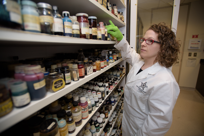 A senior Document Analyst evaluates the inks on display in the International Ink Library. The library is dedicated to Dr. Antonio Cantu, a renowned investigator and former USSS Chief Chemist who began collecting samples in the 1960s.